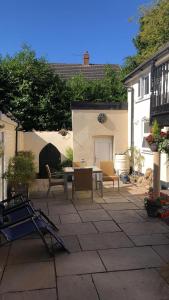 a patio with a table and chairs and a building at Pitfield Apartments in Willand