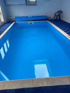 a large blue swimming pool in a room at Pitfield Apartments in Willand