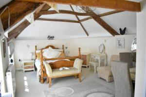 a bedroom with a bed and a chair and a desk at Pitfield Apartments in Willand