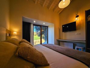 een slaapkamer met een groot bed met een groot raam bij Apartamentos Estela de Altamira in Santillana del Mar +36 foto's