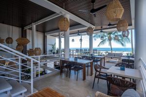 a restaurant with tables and chairs and a view of the ocean at Ozeano Hotel & Surf Bar in Jacó