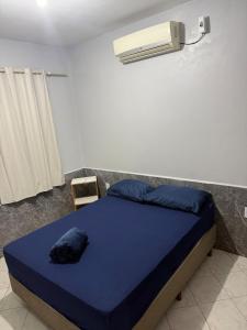 a bedroom with a bed with blue sheets and a light at Casa Premium com Jacuzzi e Churrasqueira in Palhoça
