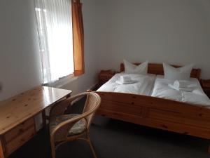 a bedroom with a bed with a desk and a chair at Alt Coswigerhof in Coswig