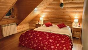 una camera da letto con letto rosso in mansarda di Chata nad Roztokami a Baligród
