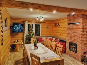 una sala da pranzo con un tavolo e un albero di Natale di Chata nad Roztokami a Baligród