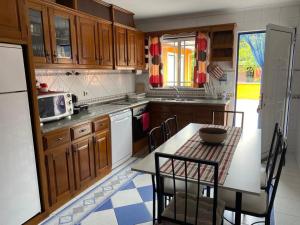 a kitchen with wooden cabinets and a table with chairs at Quinta do Marnoto in Gafanha do Carmo