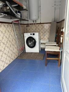a laundry room with a washing machine and a chair at Quinta do Marnoto in Gafanha do Carmo