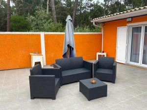 a patio with two chairs and an umbrella at Quinta do Marnoto in Gafanha do Carmo