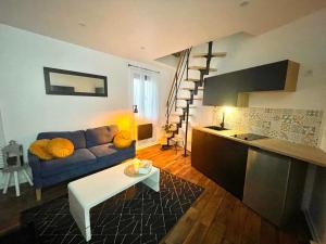 een woonkamer met een blauwe bank en een tafel bij La Bulle Bleue Jacuzzi in Épernay