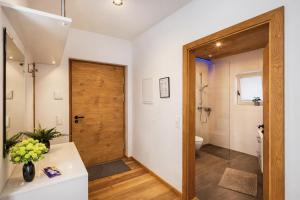 bagno con servizi igienici e porta in legno di ALTE MÜHLE LOFT - AlpenLuxus Collection a Brixlegg