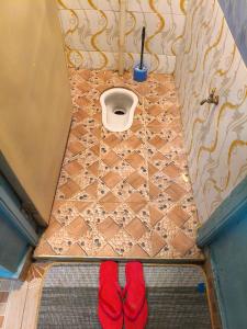 two red slippers on the floor of a bathroom with a toilet at WMSAJ HOMEs in Narok +7 photos