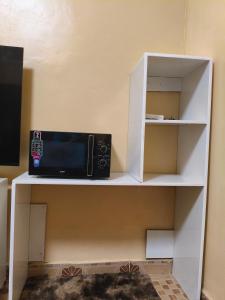 a microwave on a shelf in a room at WMSAJ HOMEs in Narok
