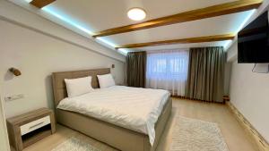 a small bedroom with a bed and a window at Parc Vatra Dornei - The 7th Haven in Vatra Dornei