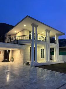 een groot wit gebouw met zuilen en een balkon bij Qayaam Lodges in Islamabad