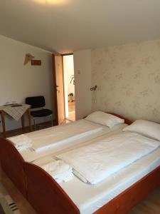 two beds in a room with a table and a chair at Pensiunea Kristine Sibiu in Sibiu