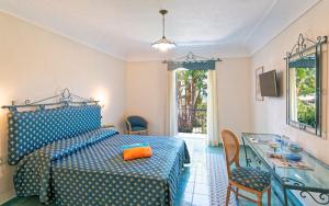 a bedroom with a bed with an orange pillow on it at Corallo Blu Hotel De Charme - Sea & Spa access in Ischia