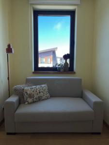 a couch in a living room with a window at Rilets Studio by BulgarianHomes in Borovets