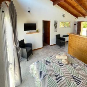 a living room with a bed and a tv at Los Nenúfares in Lago Puelo