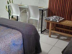 a bedroom with a table and chairs and a bed at Flat 308 in Teresina +5 photos
