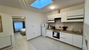 a kitchen with white cabinets and a bed in a room at Parc Vatra Dornei - The 7th Haven in Vatra Dornei +20 photos