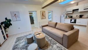 a living room with a couch and a kitchen at Parc Vatra Dornei - The 7th Haven in Vatra Dornei