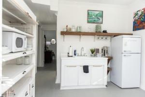 a white kitchen with a sink and a microwave at Little Noone in Jackson