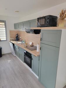 a small kitchen with a sink and a microwave at Maison Cocooning Equihen 5 pers Proche Mer & Terrasse in Équihen-Plage