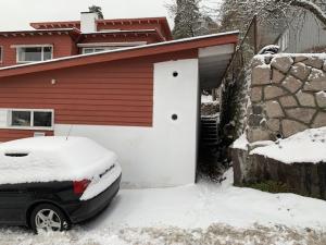 een auto geparkeerd voor een garage bedekt met sneeuw bij Studio Drammen in Drammen