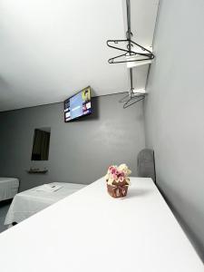 a room with a table with a vase of flowers on it at Hostel Anprado #1 Kit café incluso, Próx-Aeroporto de Guarulhos in Guarulhos +9 photos