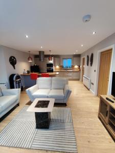 a living room with white couches and a kitchen at Durham Norwood detached Bungalow in Trimdon Grange