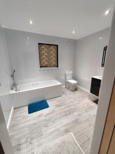a white bathroom with a tub and a toilet at Durham Norwood detached Bungalow in Trimdon Grange +12 photos