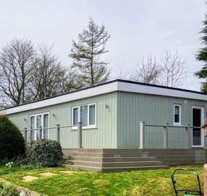 a small green building with a staircase in front of it at Durham Norwood detached Bungalow in Trimdon Grange