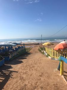 a sandy beach with umbrellas and the ocean at Love Wave House in Agadir