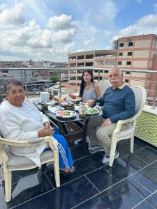 a group of people sitting at a table on a roof at New Sirius Otel in Seyhan +7 photos