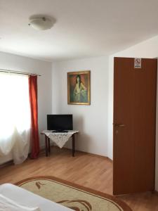 a room with a door and a table with a television at Pensiunea Kristine Sibiu in Sibiu +13 photos