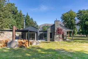 a stone house with a fireplace in the yard at Stone Cottage in Arrowtown