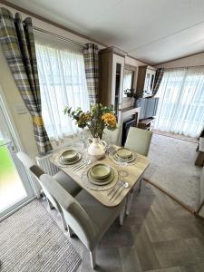 a dining room with a table and chairs with flowers on it at The Lobster Pot in Ilfracombe