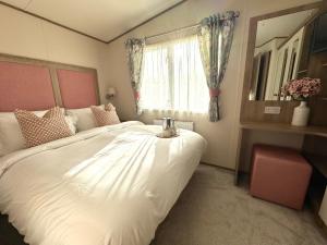 a bedroom with a large white bed and a window at The Lobster Pot in Ilfracombe