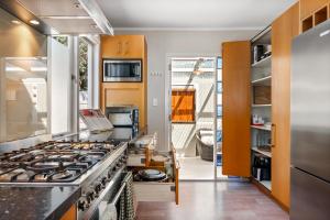 a large kitchen with a stove top oven at Silver Seas Retreat in Muriwai Beach