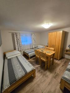 a bedroom with two beds and a table and chairs at u eli i jurka in Sztutowo