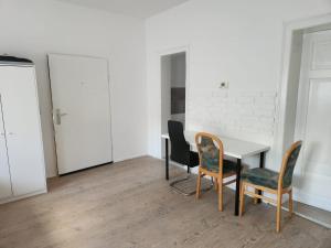 a room with a table and chairs and a white wall at Unterkunft 20 Feld Str in Schwabach