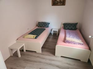 two beds in a room with two tables at Unterkunft 20 Feld Str in Schwabach