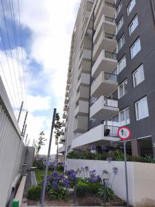 a street sign in front of a tall building at Nuevo departamento cercano a playa y comercio in Viña del Mar