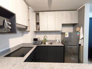 a kitchen with white cabinets and a stainless steel refrigerator at Nuevo departamento cercano a playa y comercio in Viña del Mar +3 photos