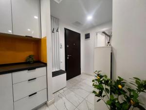 a kitchen with white cabinets and a black door at Nivora apartament #freeparking in Tunari