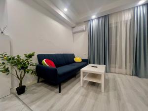 a living room with a blue couch and a table at Nivora apartament #freeparking in Tunari