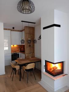 a kitchen and dining room with a fireplace at A-Apartman in Bjelašnica