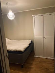 a small bedroom with a bed and a cabinet at Leilighet i Tromsø in Tromsø