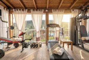 a gym with exercise equipment and a large window at Alghero Villa Flamingo Luxury Resort with exclusive pool, gym and SPA in Alghero