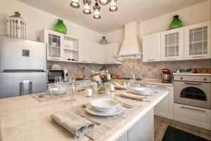 a kitchen with white cabinets and a marble counter top at Alghero Villa Flamingo Luxury Resort with exclusive pool, gym and SPA in Alghero